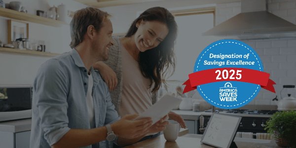Photo of man and woman doing paperwork in their kitchen together smiling, with America Save Week Award Badge overlayed